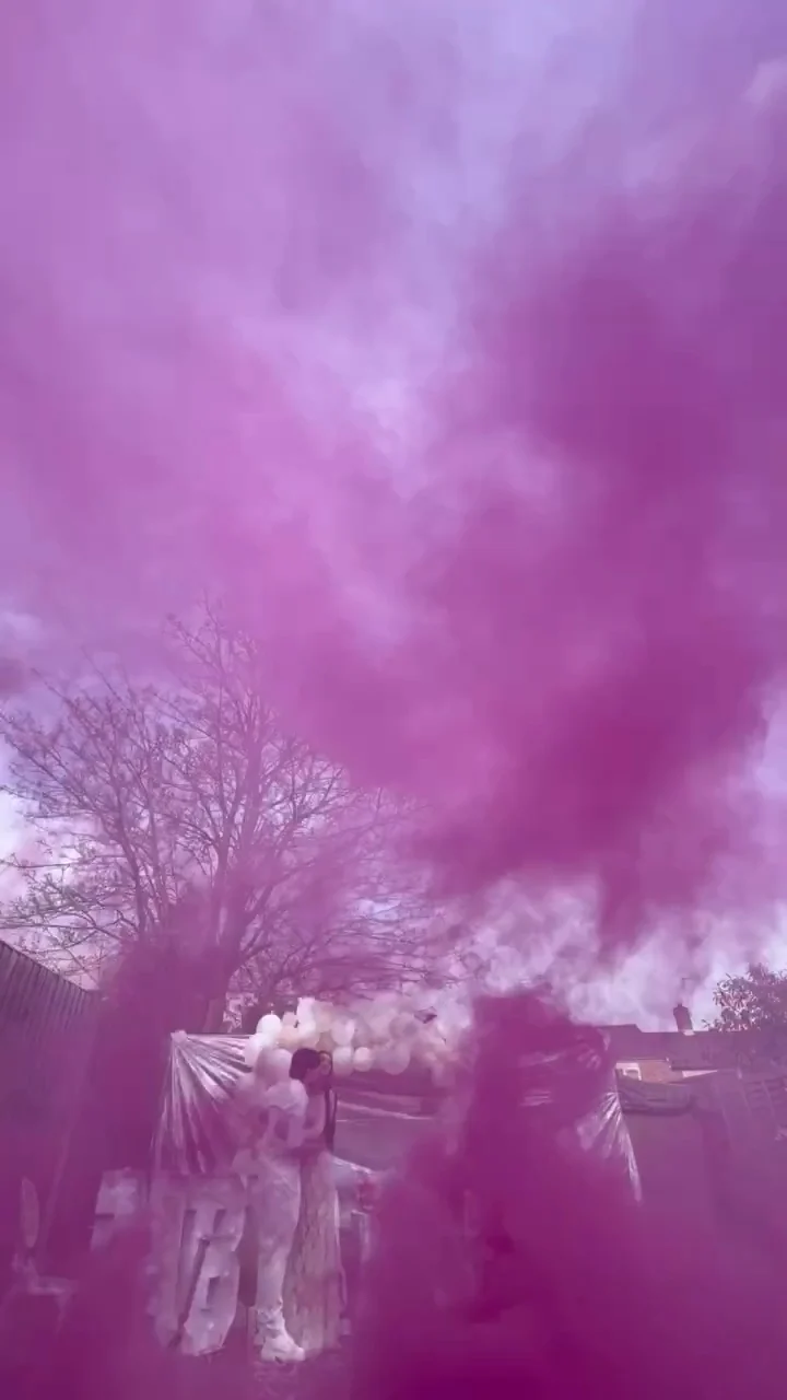 A dense pink smoke canopy spreads above a garden reveal and its guests. Illustrative reveal footage; effects vary by package.